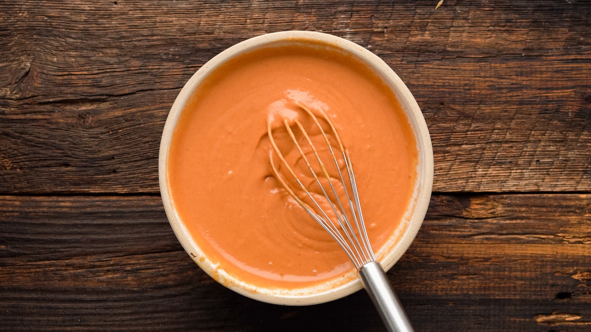 Peanut Butter and tomato paste whisked in a white bowl