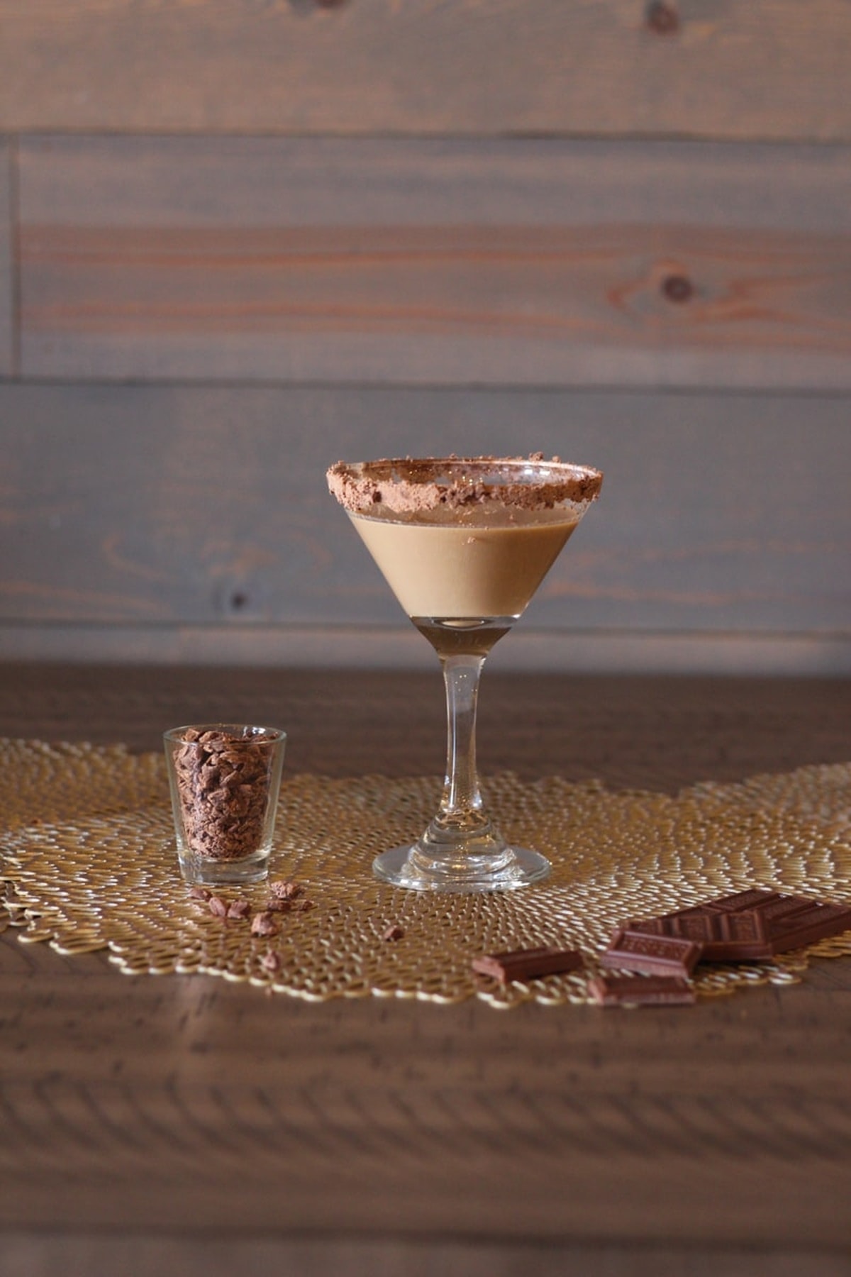 A glass of Baileys Chocolate Martini and a glass of chocolate shavings on a table.