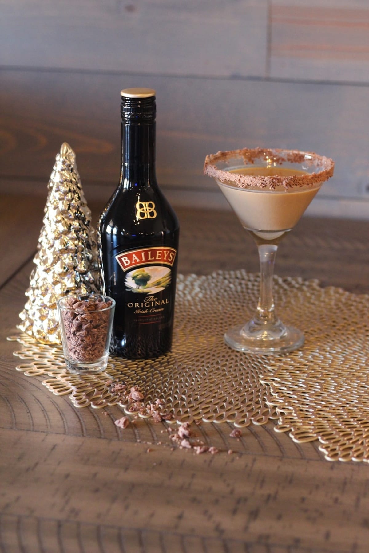 A glass of Baileys Chocolate Martini and chocolate shavings inside a glass on a table.