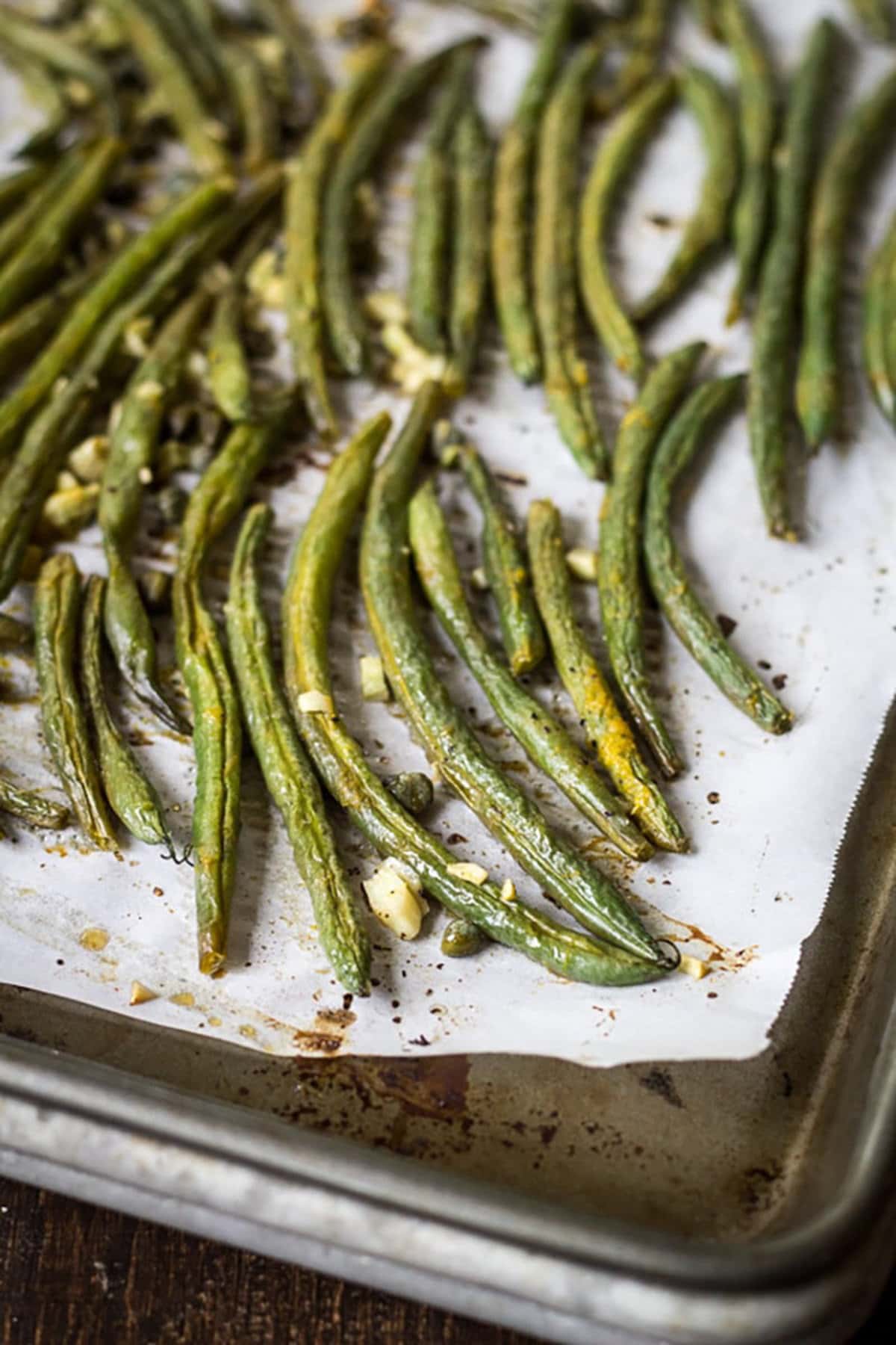 Oven Roasted Green Beans on parchment paper on a baking sheet.