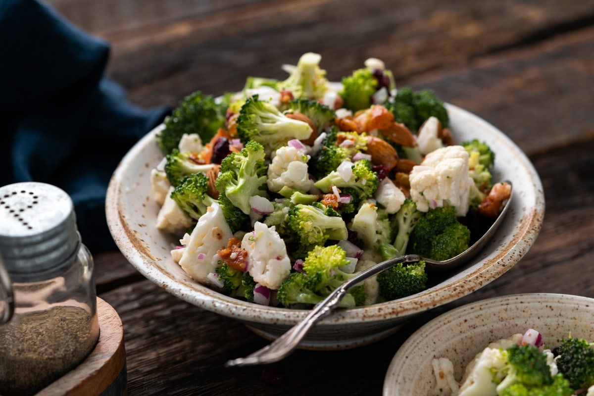 Broccoli Salad in a white bowl on a table.
