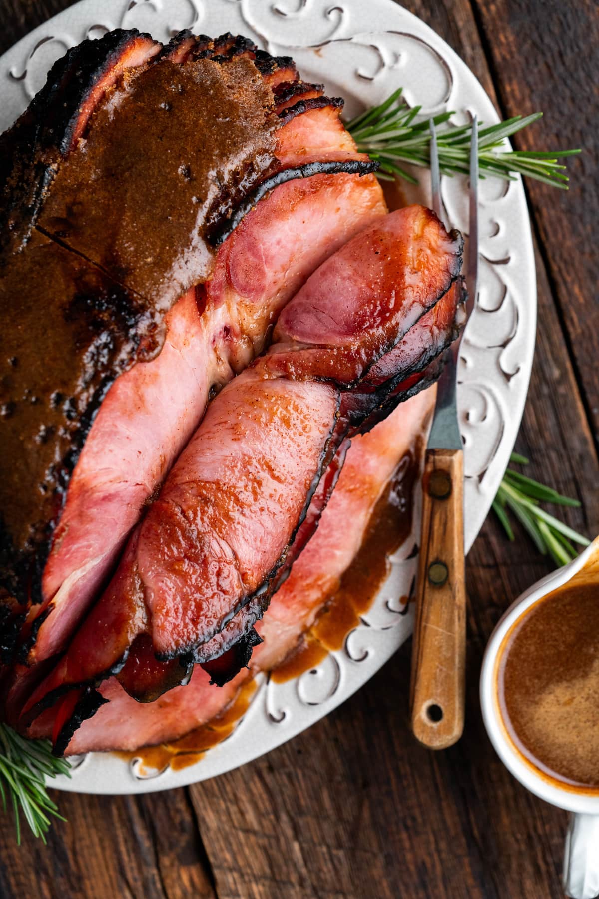 Sliced ham sitting on a serving plate.
