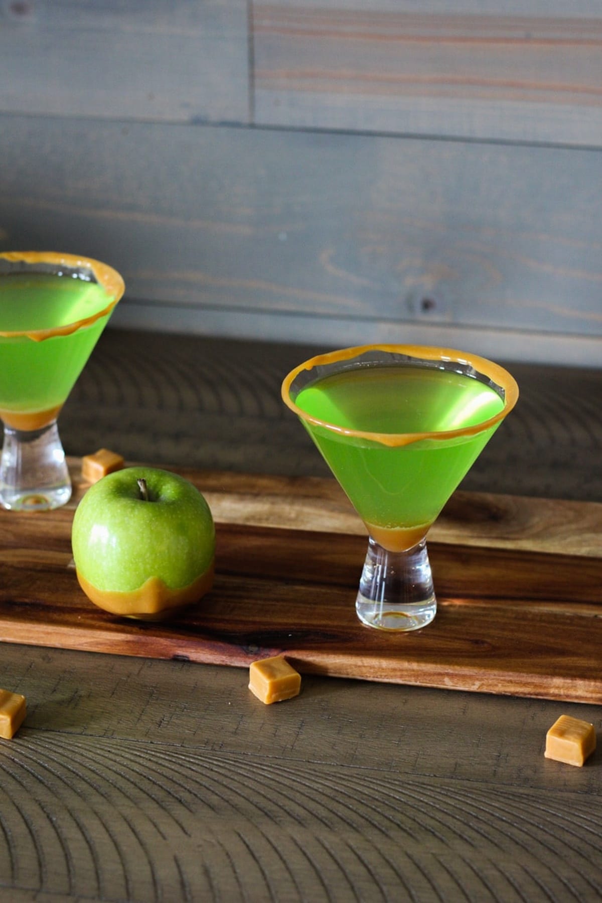 A glass of caramel apple martini on a table.