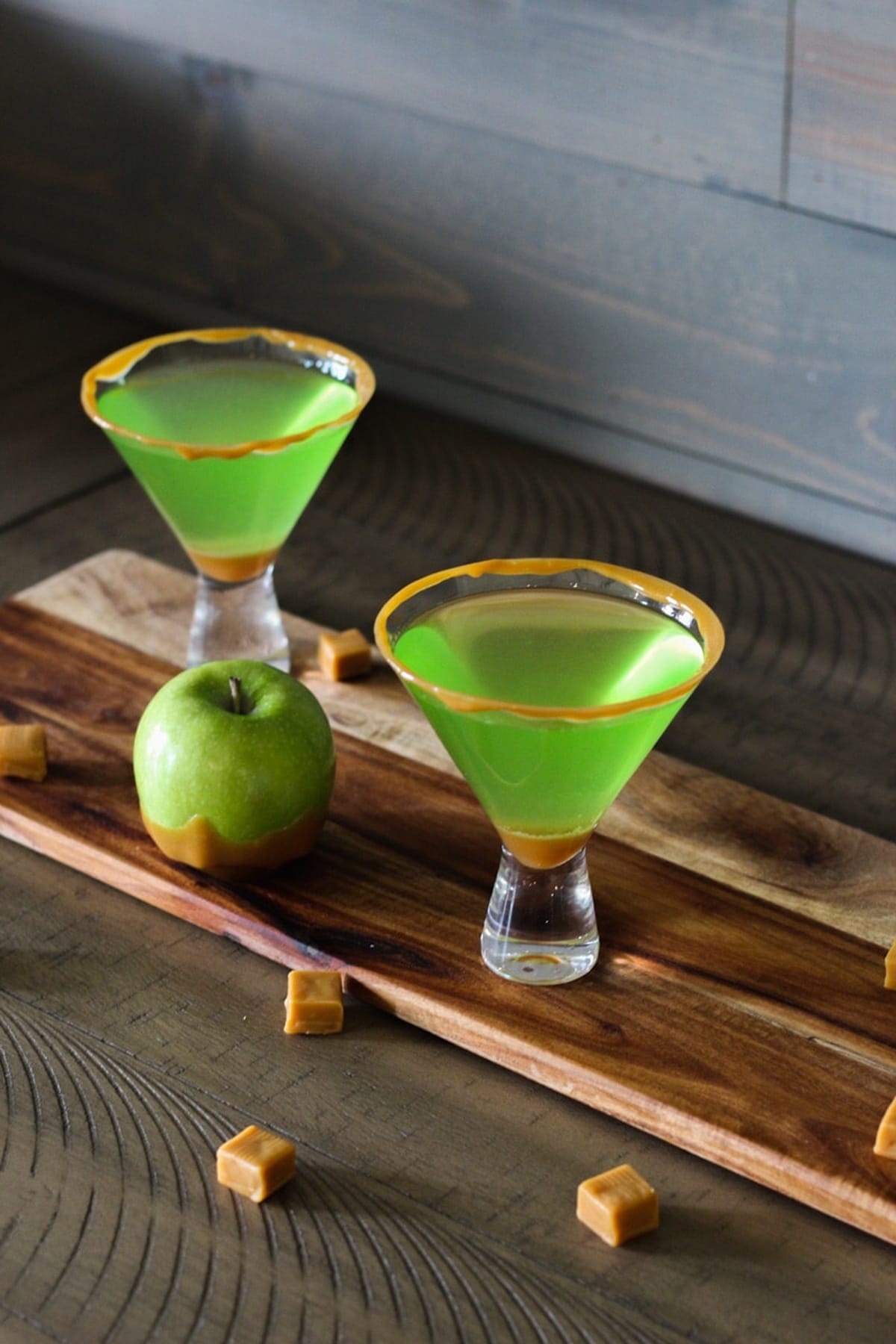 Two glasses of caramel apple martinis served on a table.