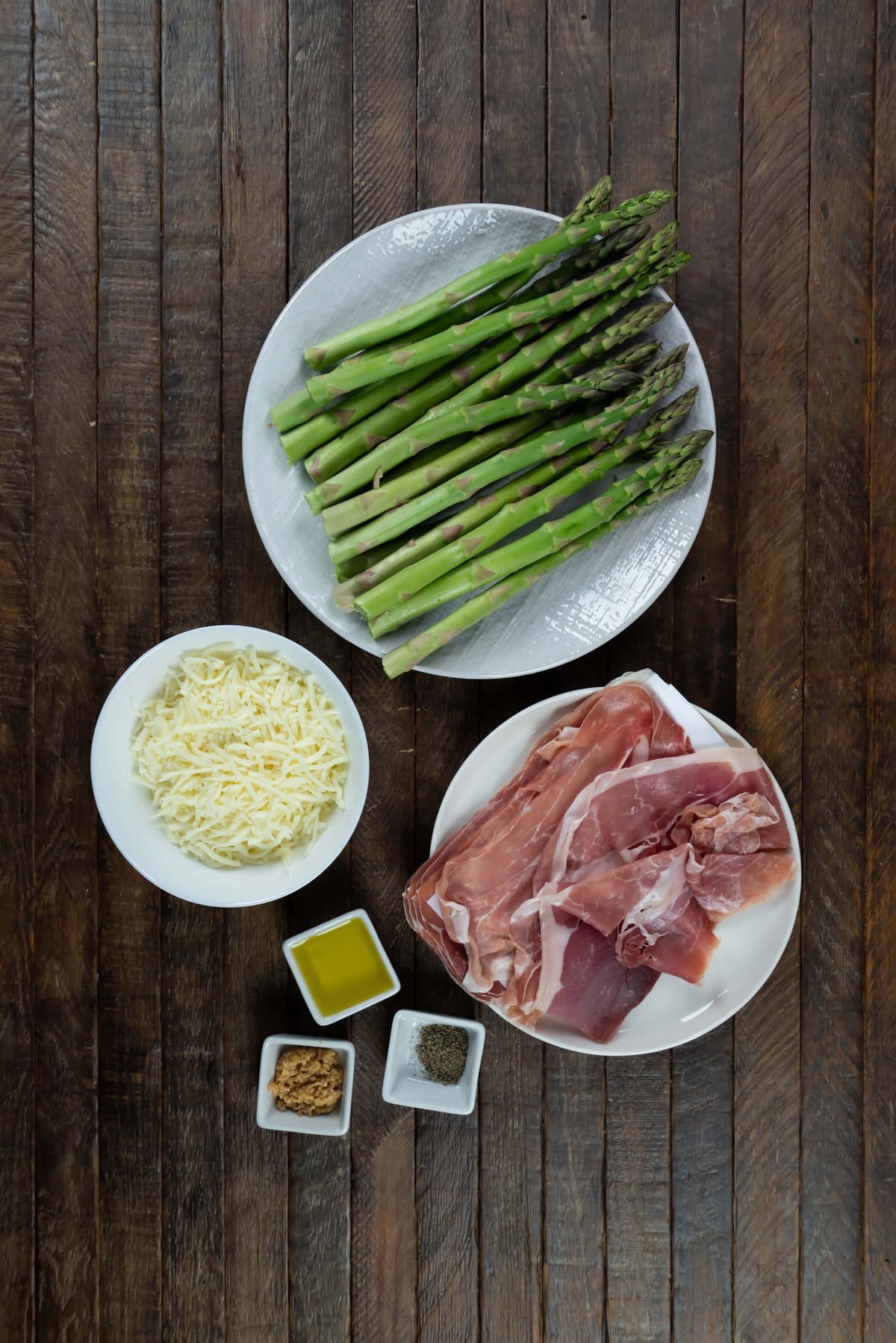 Cheesy baked asparagus ingredients gathered on a table.