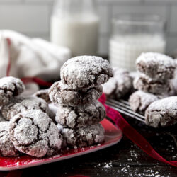 Chocolate crinkle cookies stacked on a plate.