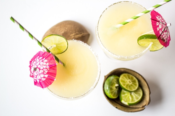 This "from-scratch" frozen coconut margaritas recipe uses lime juice and agave nectar in place of syrupy pre-made mix. Blended with coconut tequila and served with a coconut-salt rim, these tropical drinks will whisk you away to paradise!