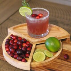 Cranberry Margarita cocktail in a glass with a sugared rim on a wooden board.