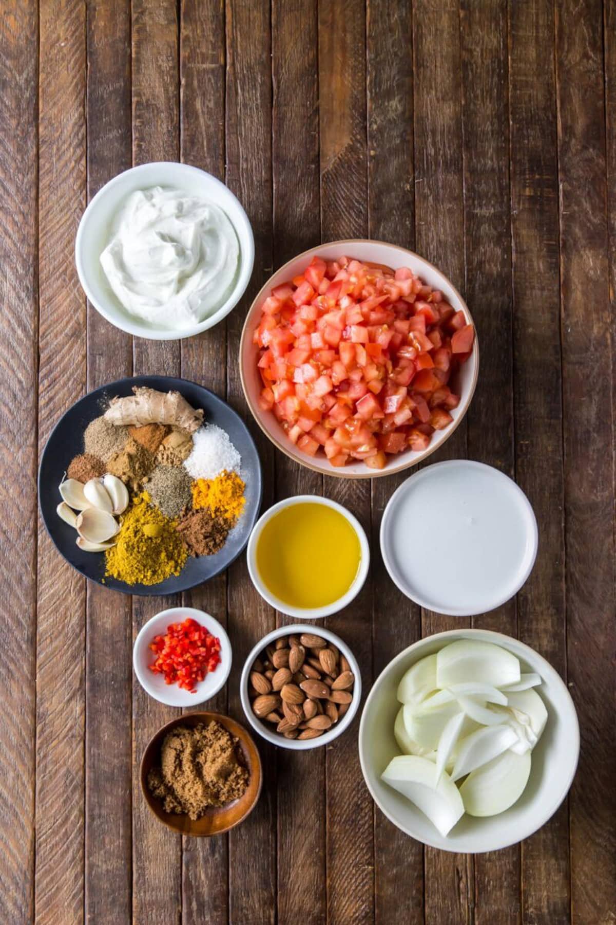 Ingredients for chicken korma sauce in bowls.