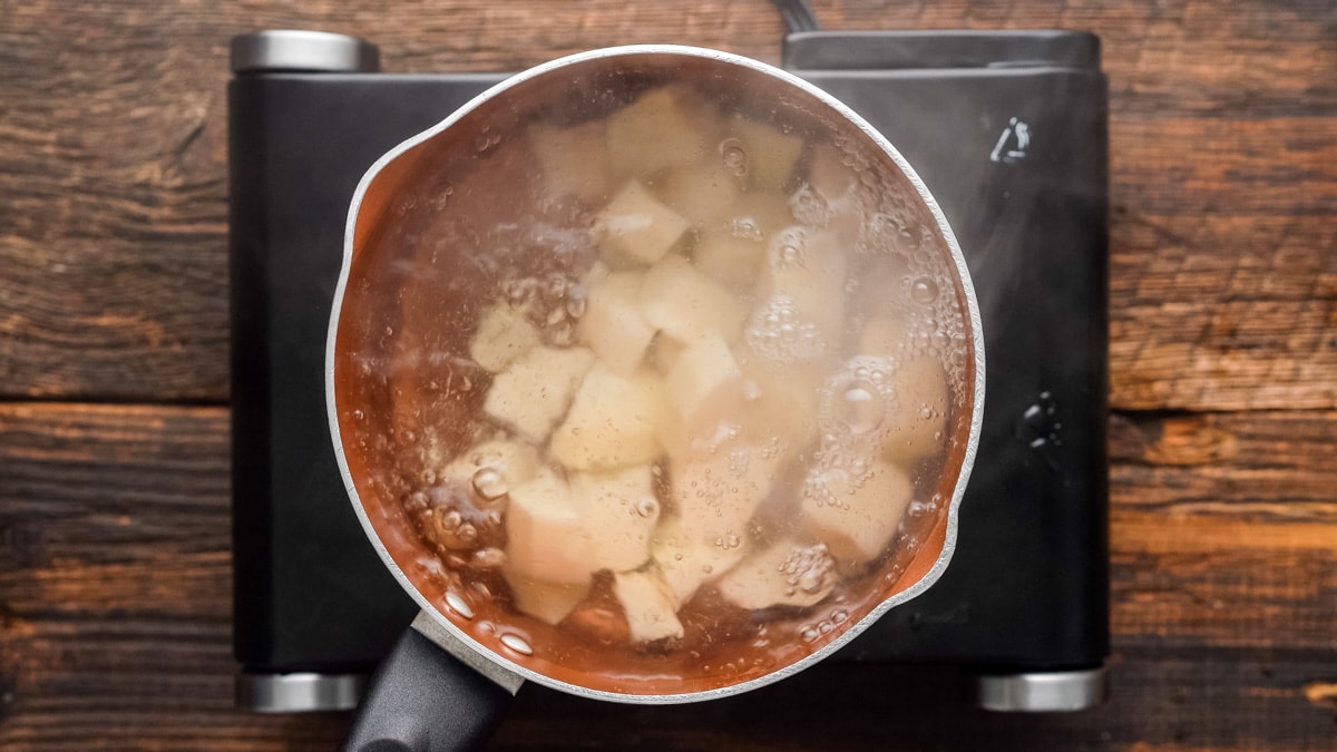 Potato chunks boiling in a pot of water.