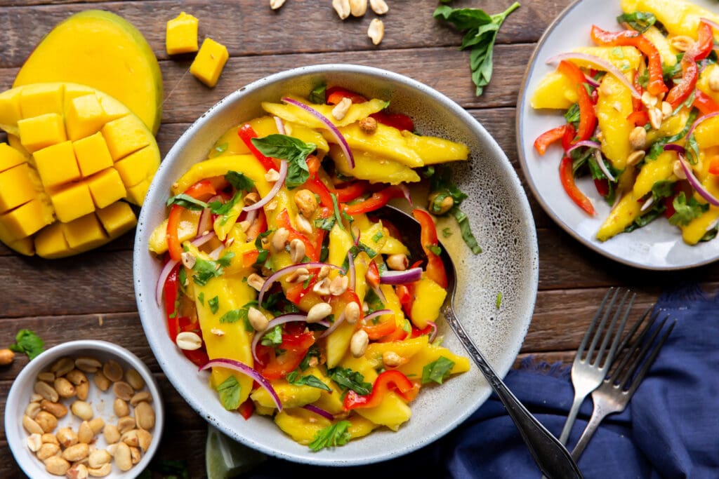 Want a mango salads? Here is one!  This Mango Salad recipe has sweet mangoes, crisp bell peppers and onions, and a tangy lime dressing that all pairs together perfectly!