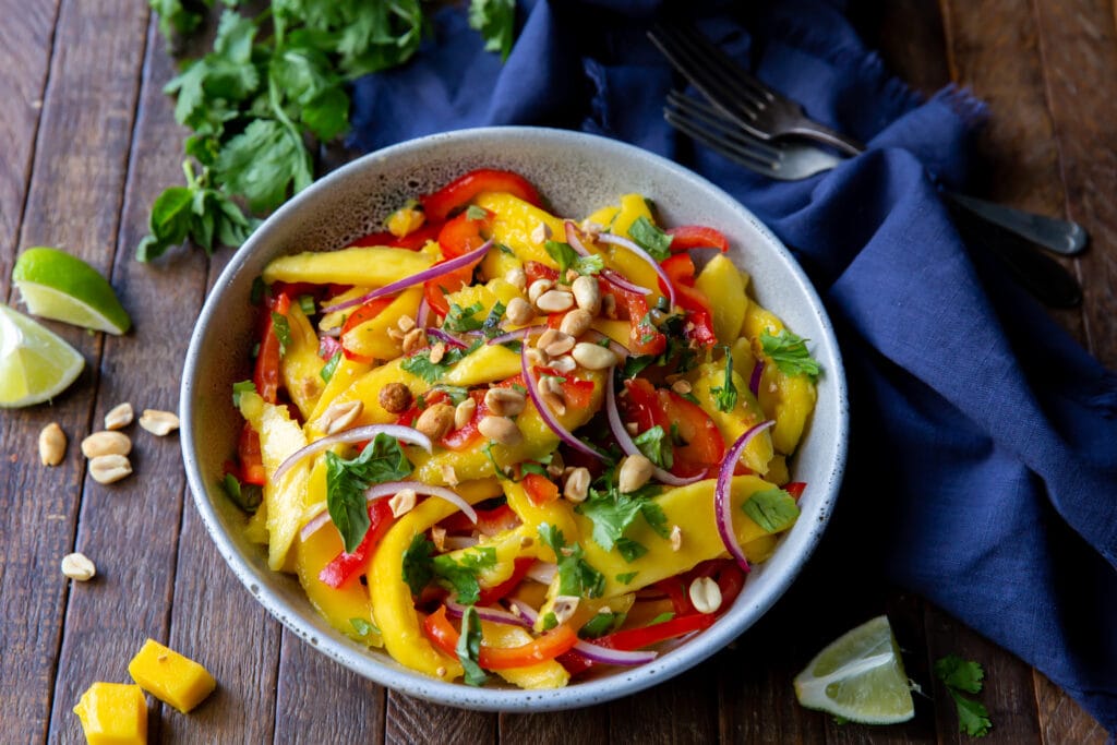 Looking for a mango salads recipes? Here is one! This Mango Salad recipe has sweet mangoes, crisp bell peppers and onions, and a tangy lime dressing that all pairs together perfectly!