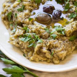 Melitzanosalata, or Greek Eggplant Dip, is a simple yet tasty dish of roasted eggplant, garlic, oil, and lemon juice. It's perfect spread on toasted bread, or as party of a larger Greek meze party!