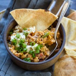 This Menemen recipe (aka Turkish scrambled eggs recipe) combines eggs, onion, bell pepper, tomatoes, feta cheese, garlic and spices to smear over toasted pita chips for a hearty breakfast or an easy weeknight dinner. 
