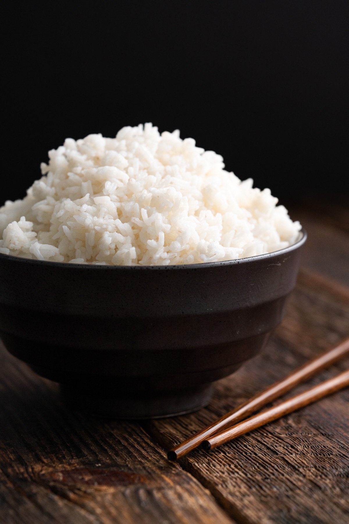 Bowl of white rice with chopsticks on the table