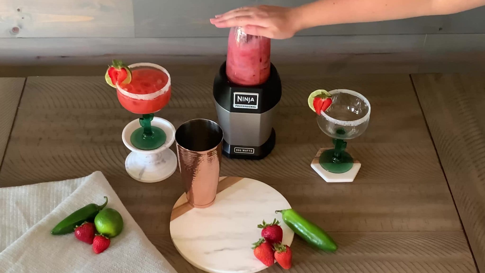 A blender blending strawberries and tequila
