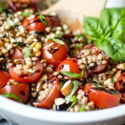 Whether you call it "pearl couscous" or "Israeli couscous," there's everything to love about these little balls of pasta. In this recipe, chilled couscous is coated in a simple olive oil dressing, then tossed with tomatoes, basil, and almonds before being finished with a generous drizzle of balsamic glaze. Healthy and delicious!