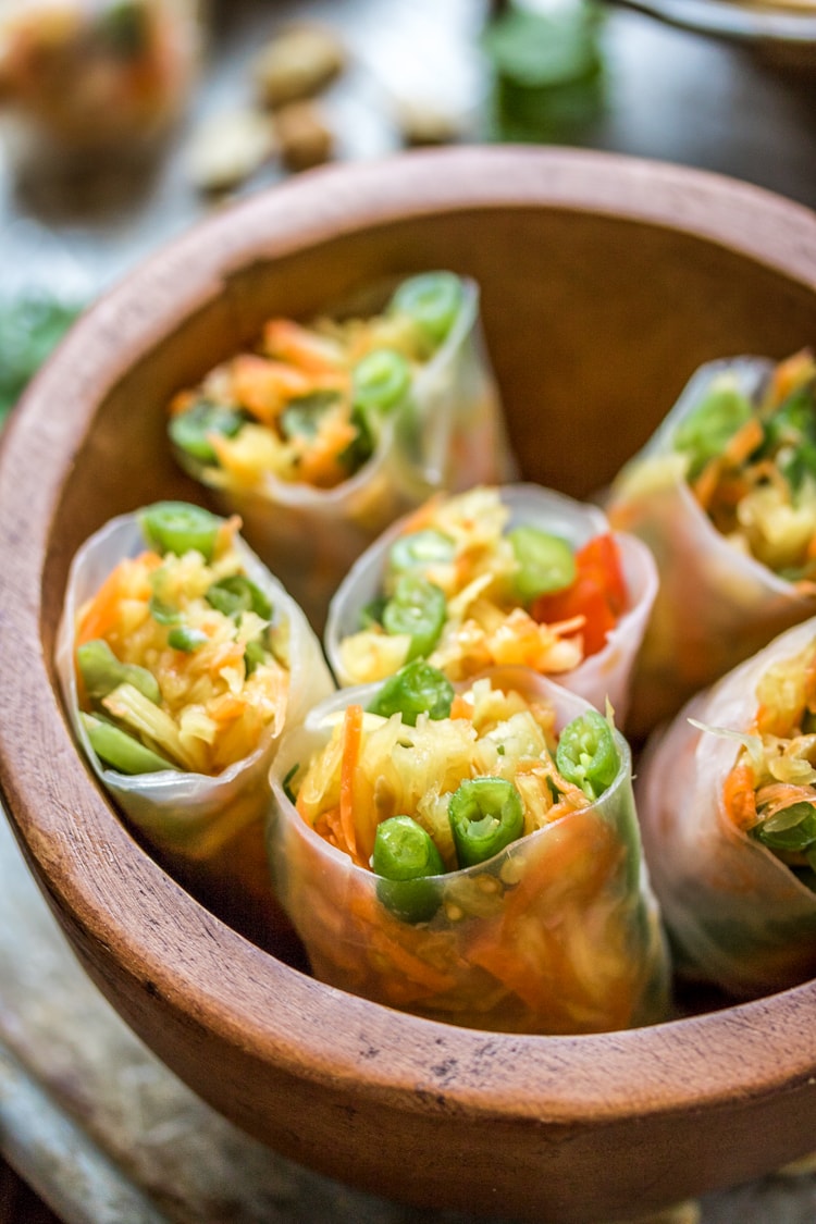 This Thai Style Papaya Salad Rolls recipe wraps up green beans, carrots, tomatoes, green papaya and peanuts with a peanut sauce for a delicious appetizer when you can't decide between fresh rolls and papaya salad!