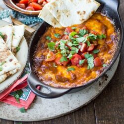 Colorado sauce made from smoky peppers adds a kick to this meatless queso fundido recipe. Serve it hot with plenty of tortillas and chips for dipping!